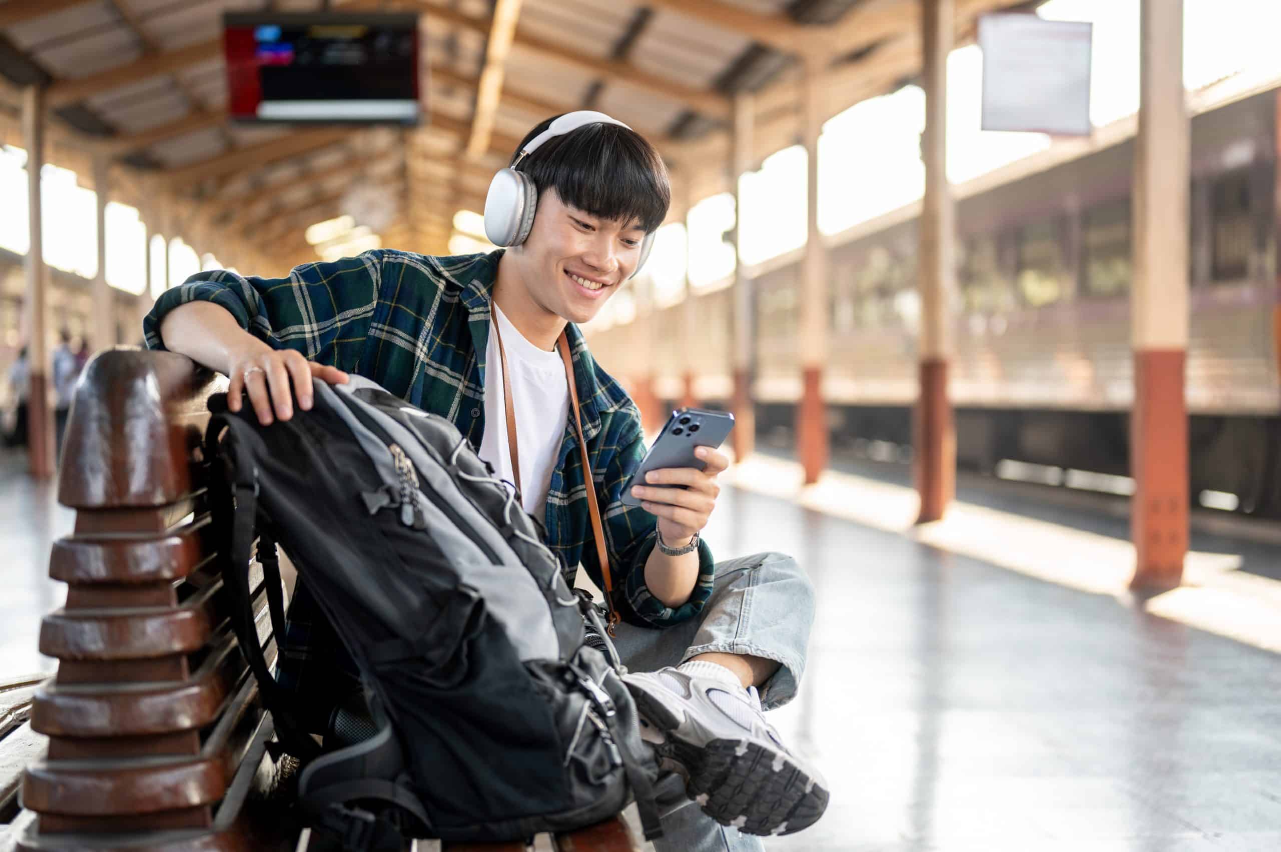 A happy and carefree man backpacker is listening to a Commuter Trax playlist