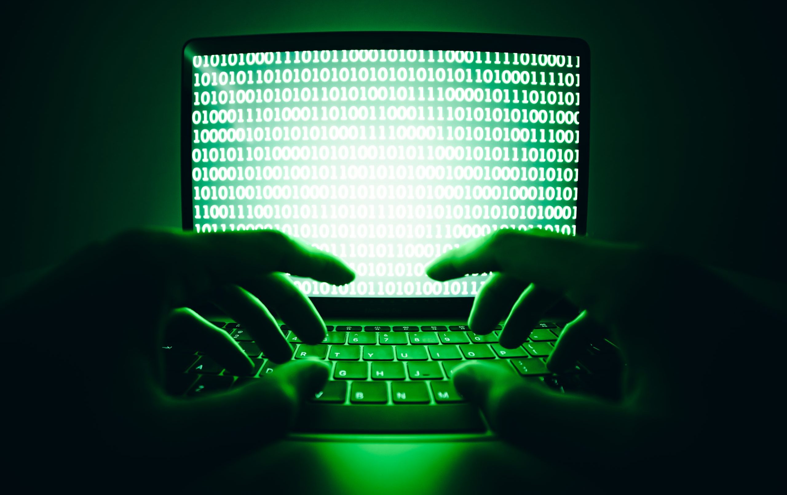 Closeup of a stream fraudster using the laptop computer to produce artificial streams and botting on a Digital Streaming Platform (DSP).