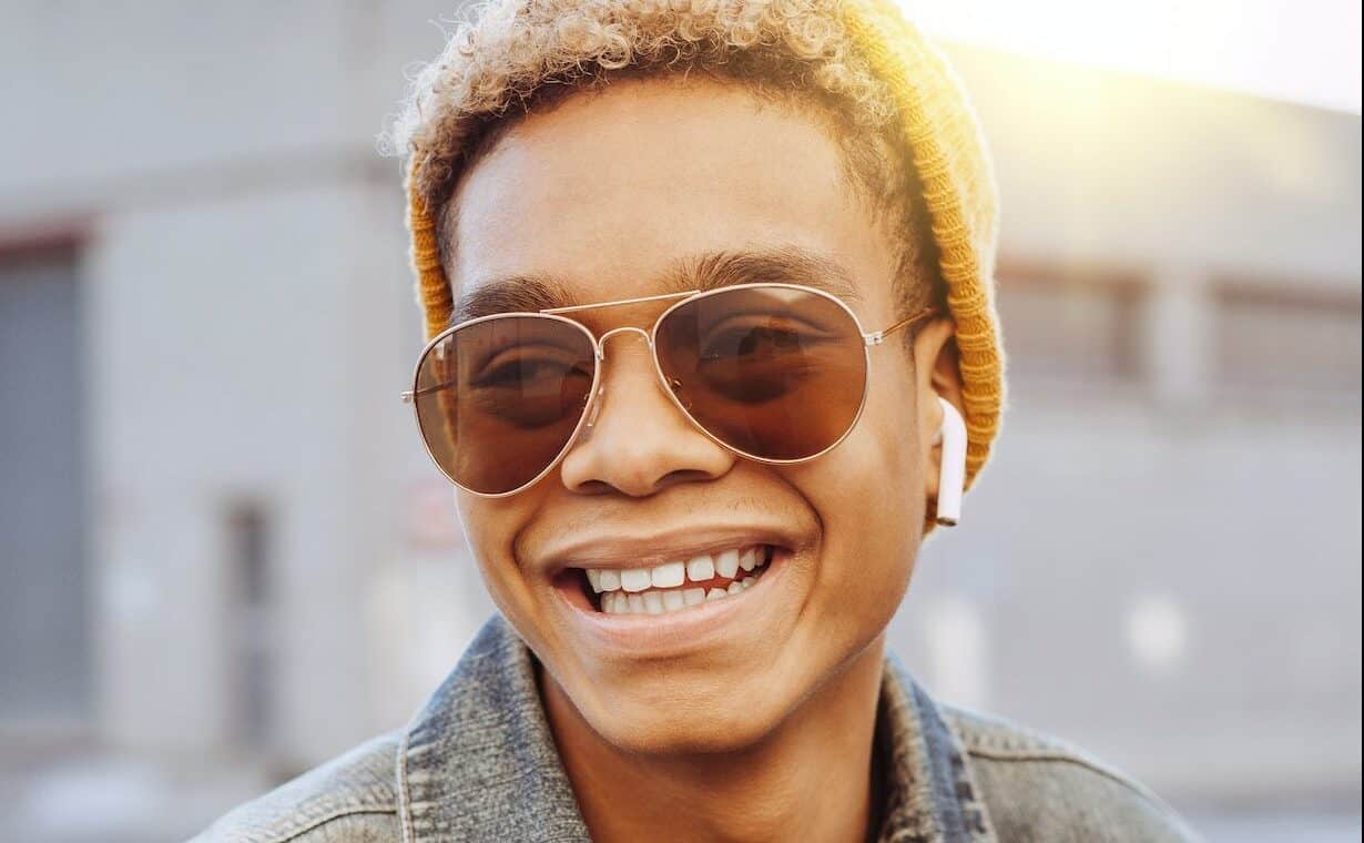 young man listening to a Commuter Trax playlist with airpods on