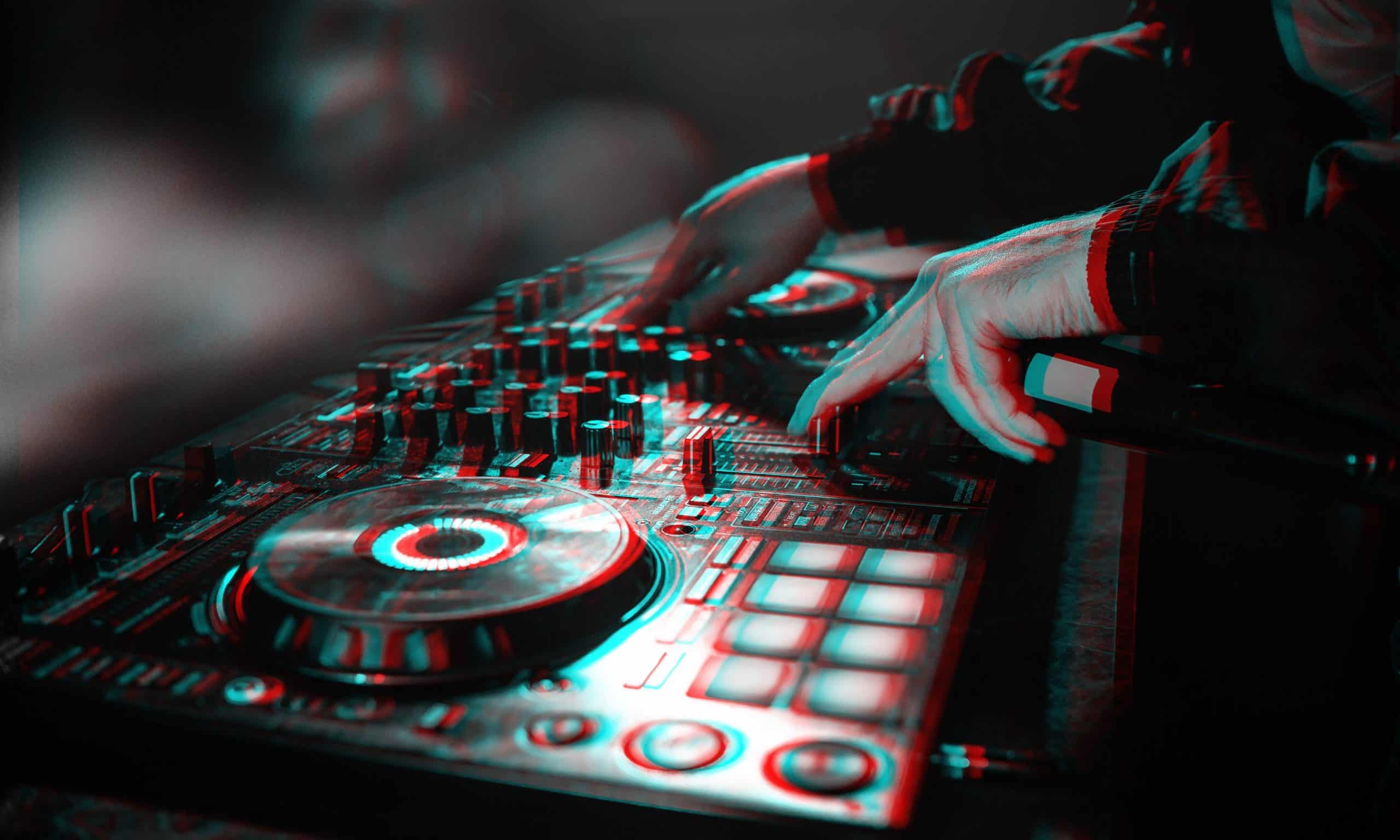 DJ console for mixing music with hands and with blurred people at a night club. Black and white with 3D glitch virtual reality effect